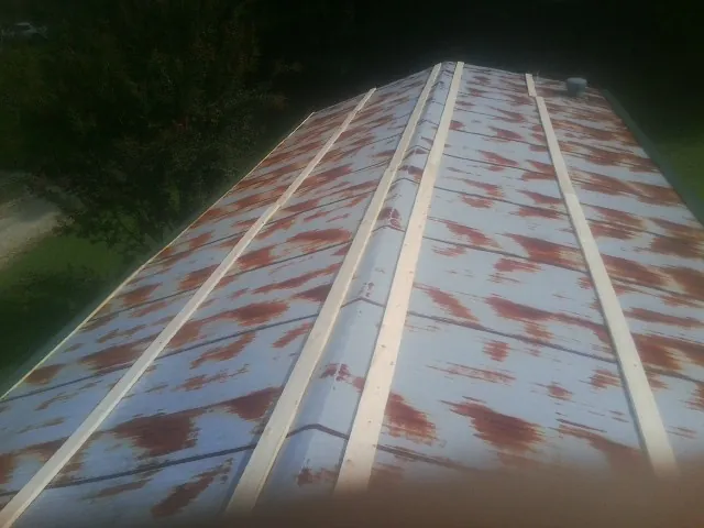 Rusted metal roof panels with new wood purlins before replacement — Storm Damage Roof Repair in Whittaker by Roofing Brothers