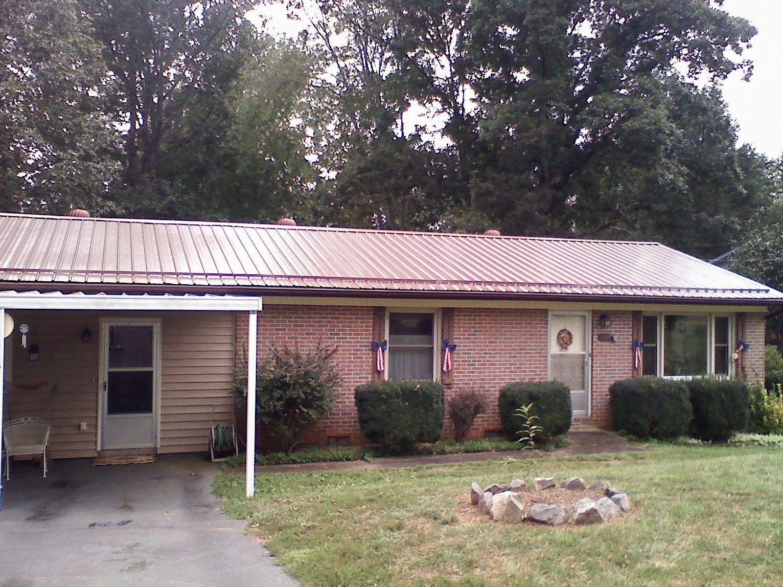 Bronze metal roof and carport on a brick ranch home — Roof Repair work by our crew in Whittaker